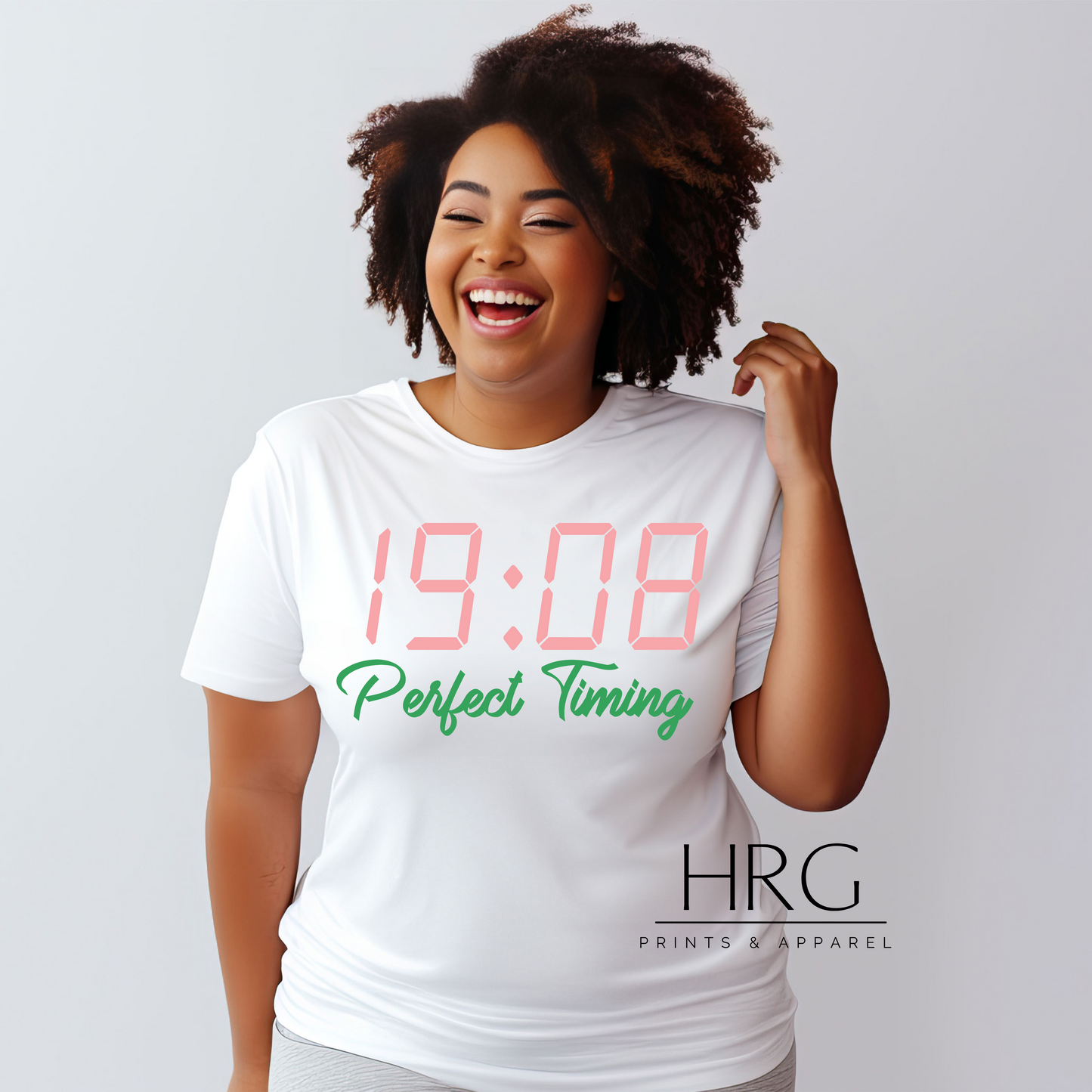 "Perfect Timing 1908 AKA-inspired t-shirt featuring pink digital clock design and green text worn by a smiling black woman."